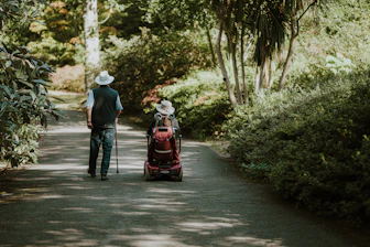 a man and a woman walking down a dirt road