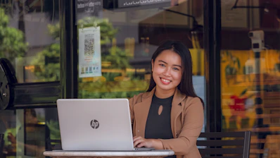 a woman sitting at a table with a laptop