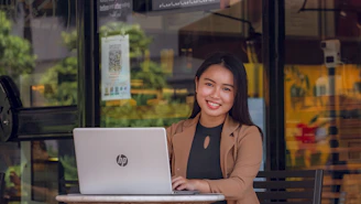 a woman sitting at a table with a laptop