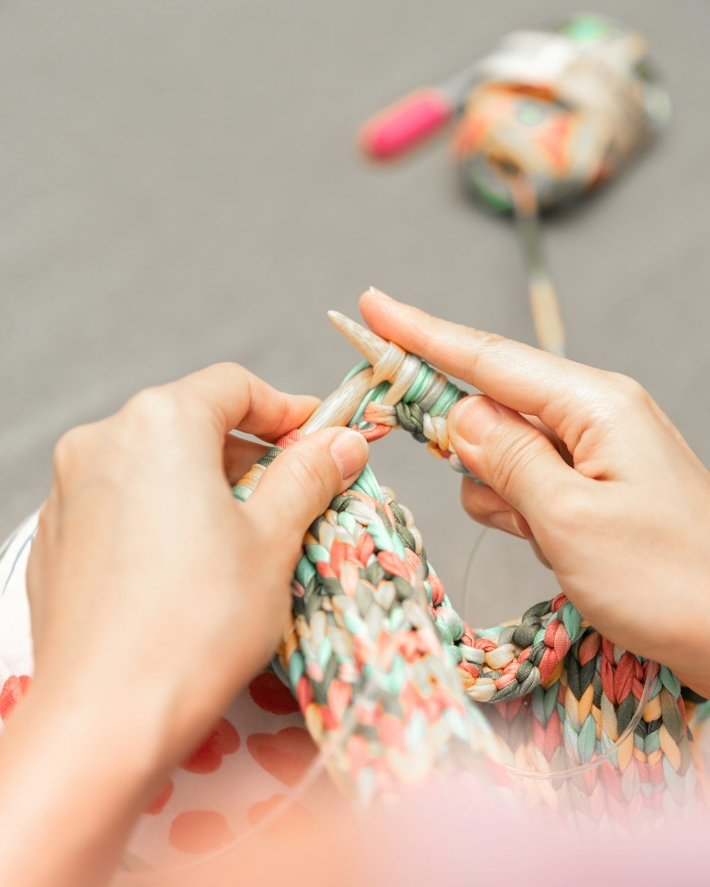 Una donna sta lavorando a maglia un pezzo di tessuto