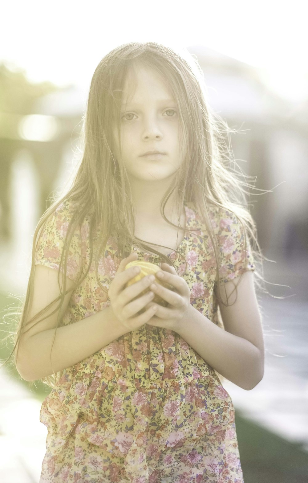 a young girl holding a piece of food in her hands