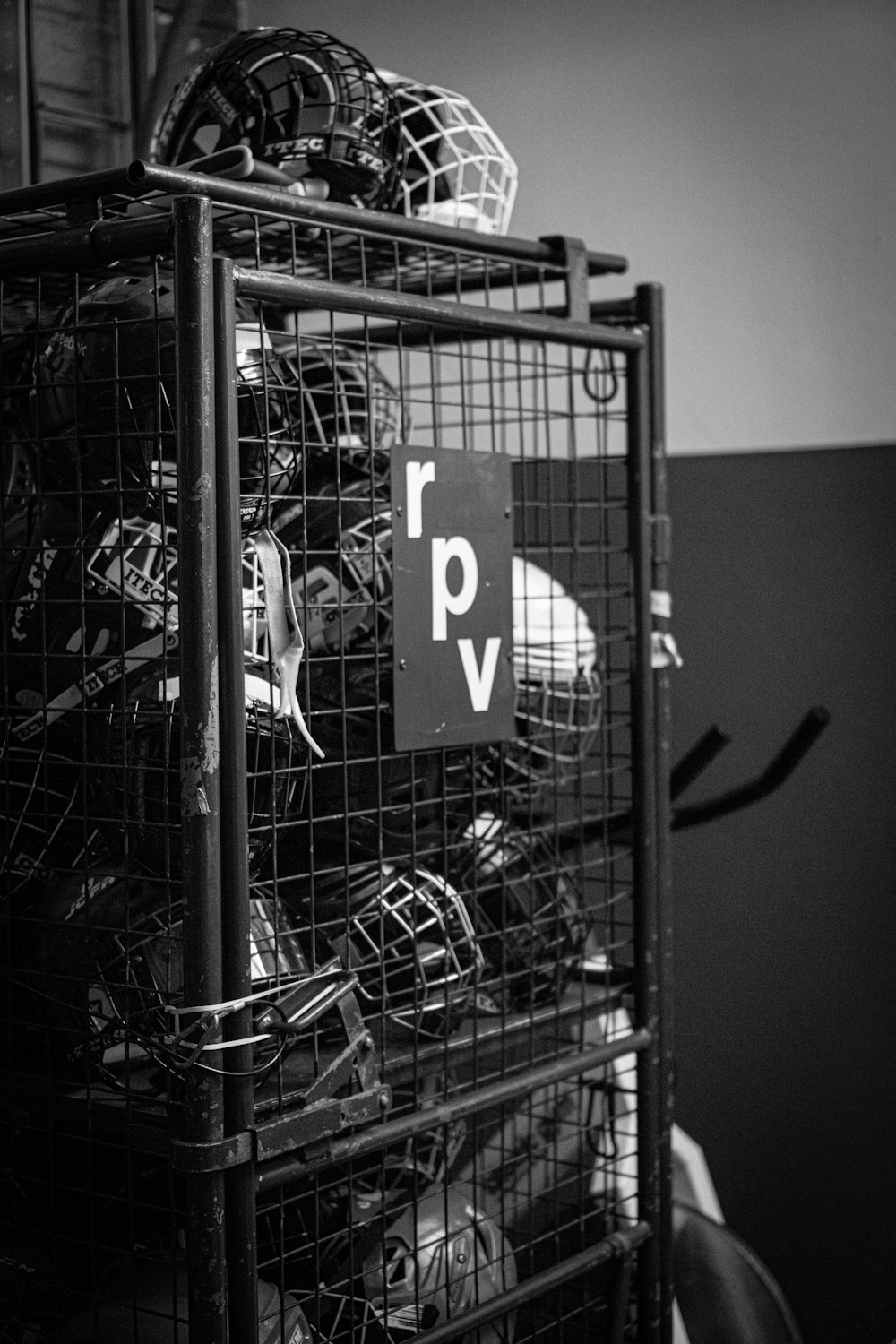 a black and white photo of a wire cage with a sign on it