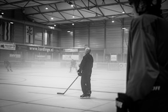 a man standing on a hockey rink holding a hockey stick
