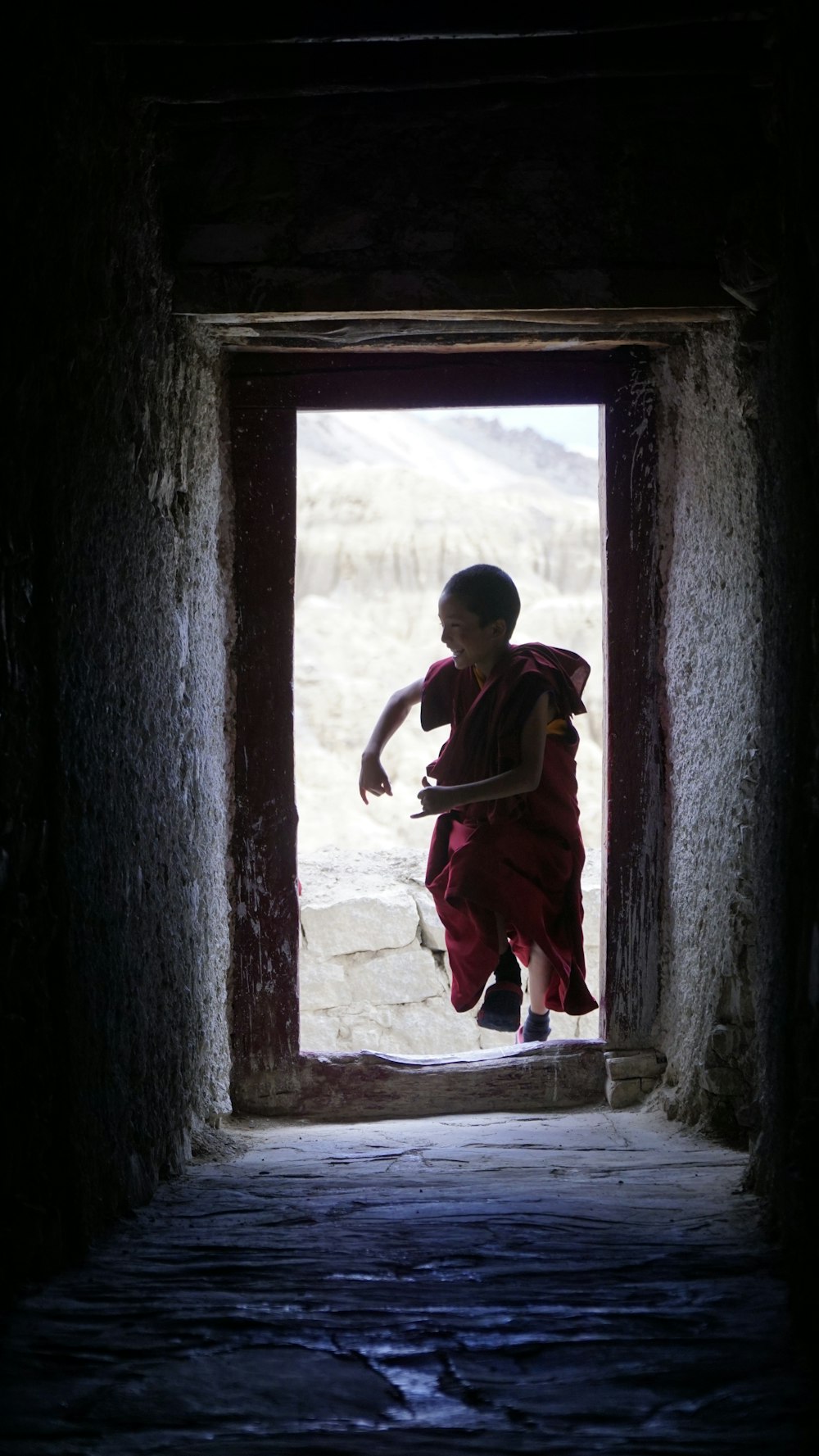 a young boy in a doorway with a skateboard