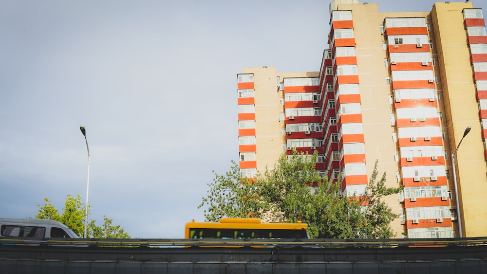 a yellow bus driving down a street next to tall buildings