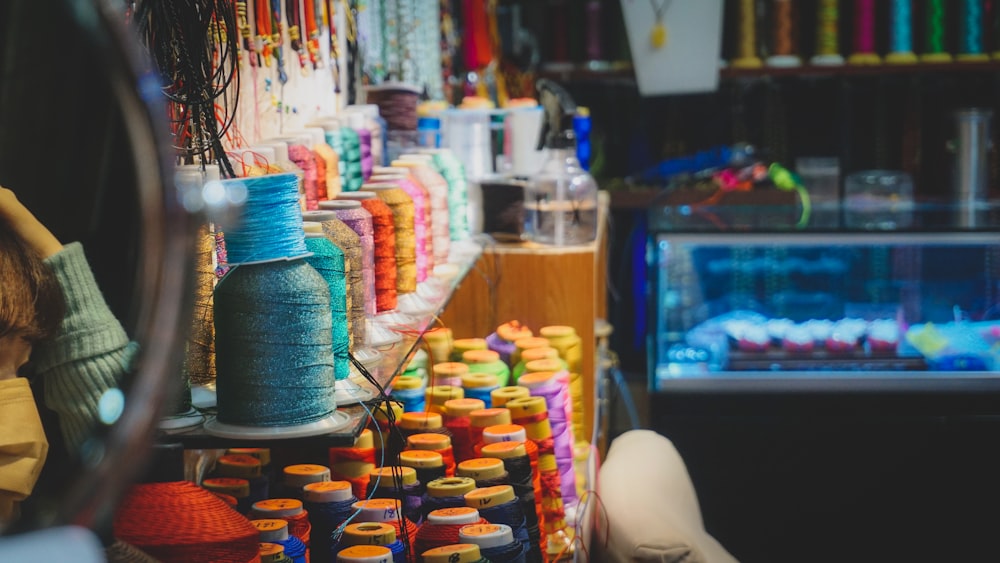 a store filled with lots of different colored spools of thread