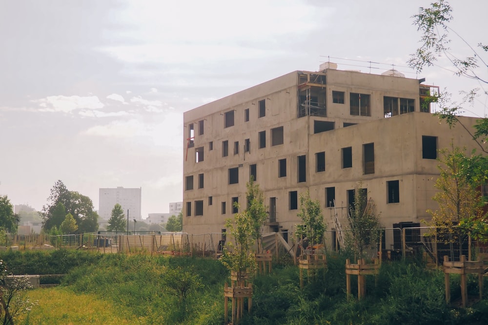 a very tall building sitting next to a lush green field