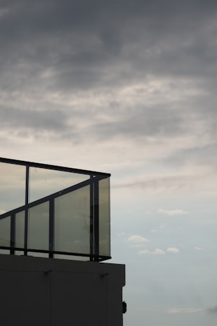 Elegant glazed glass balcony railing overlooking a cityscape at dusk.