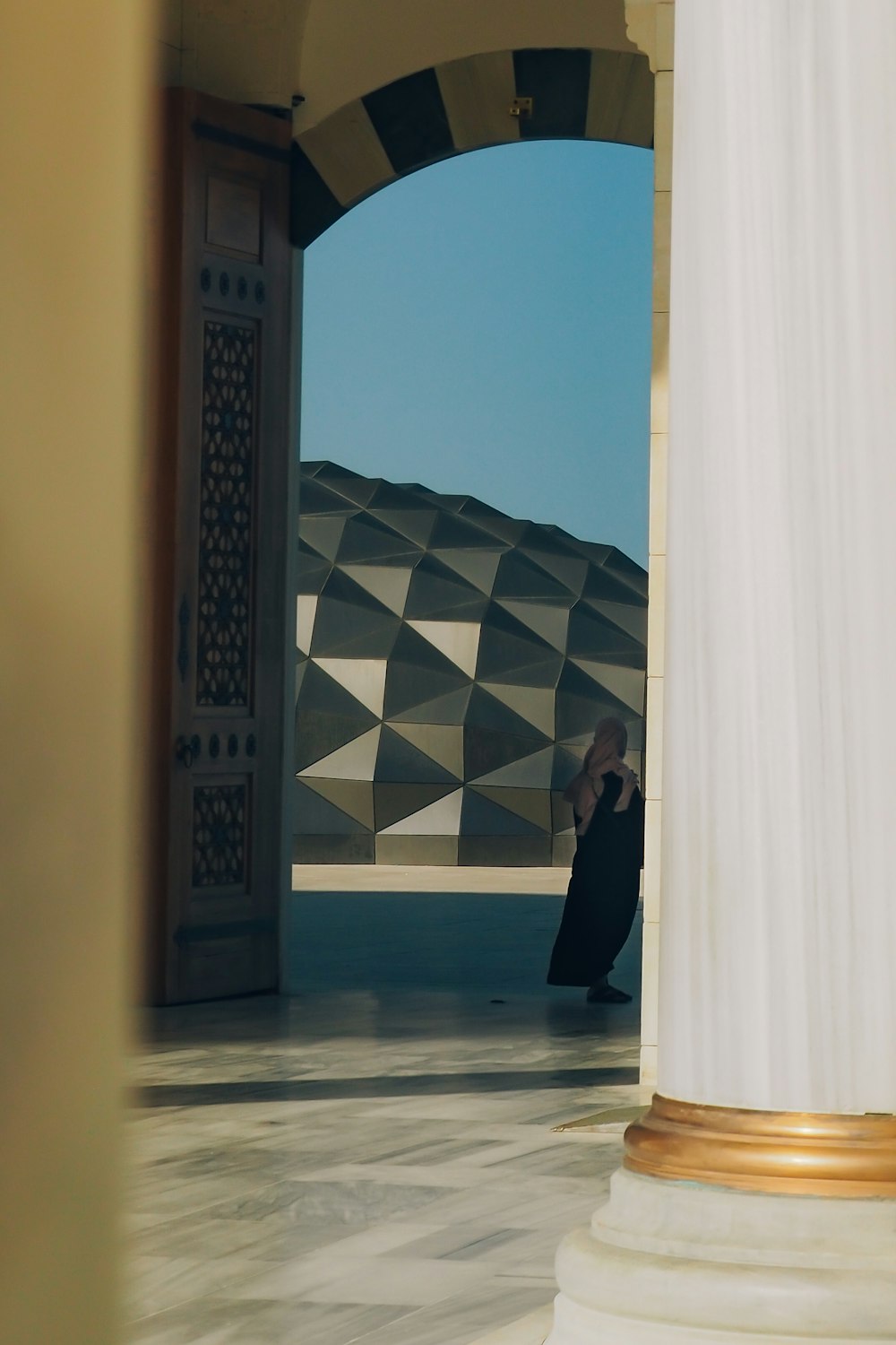 Eine Frau in einem langen schwarzen Kleid steht in einer Tür