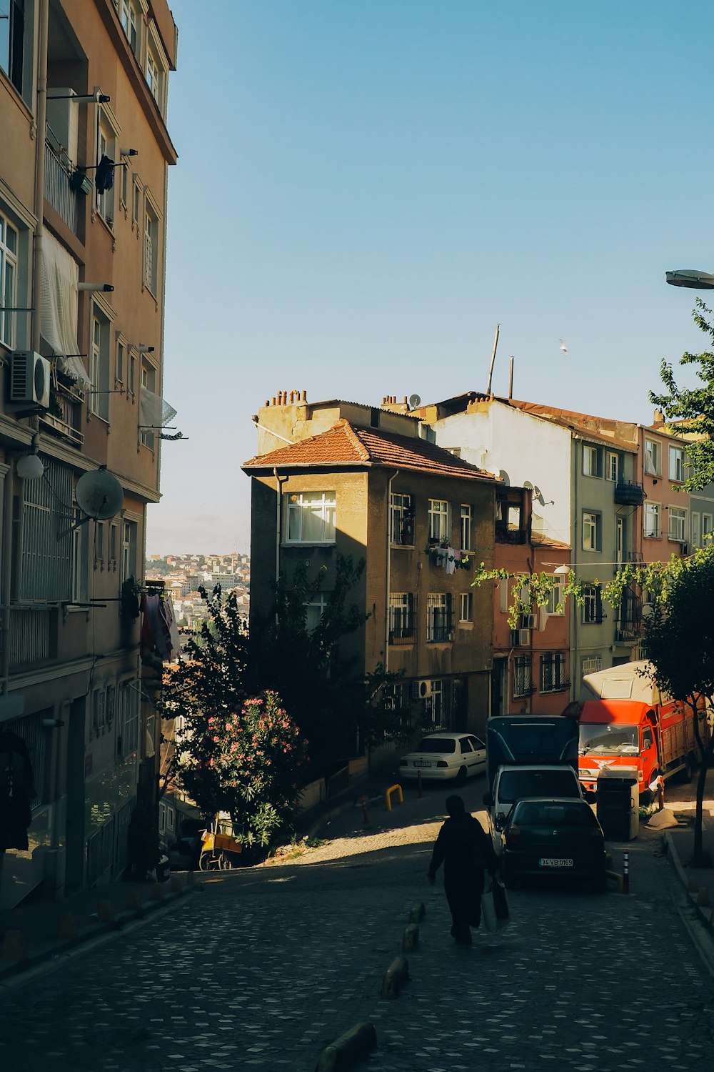 a man walking down a street next to tall buildings