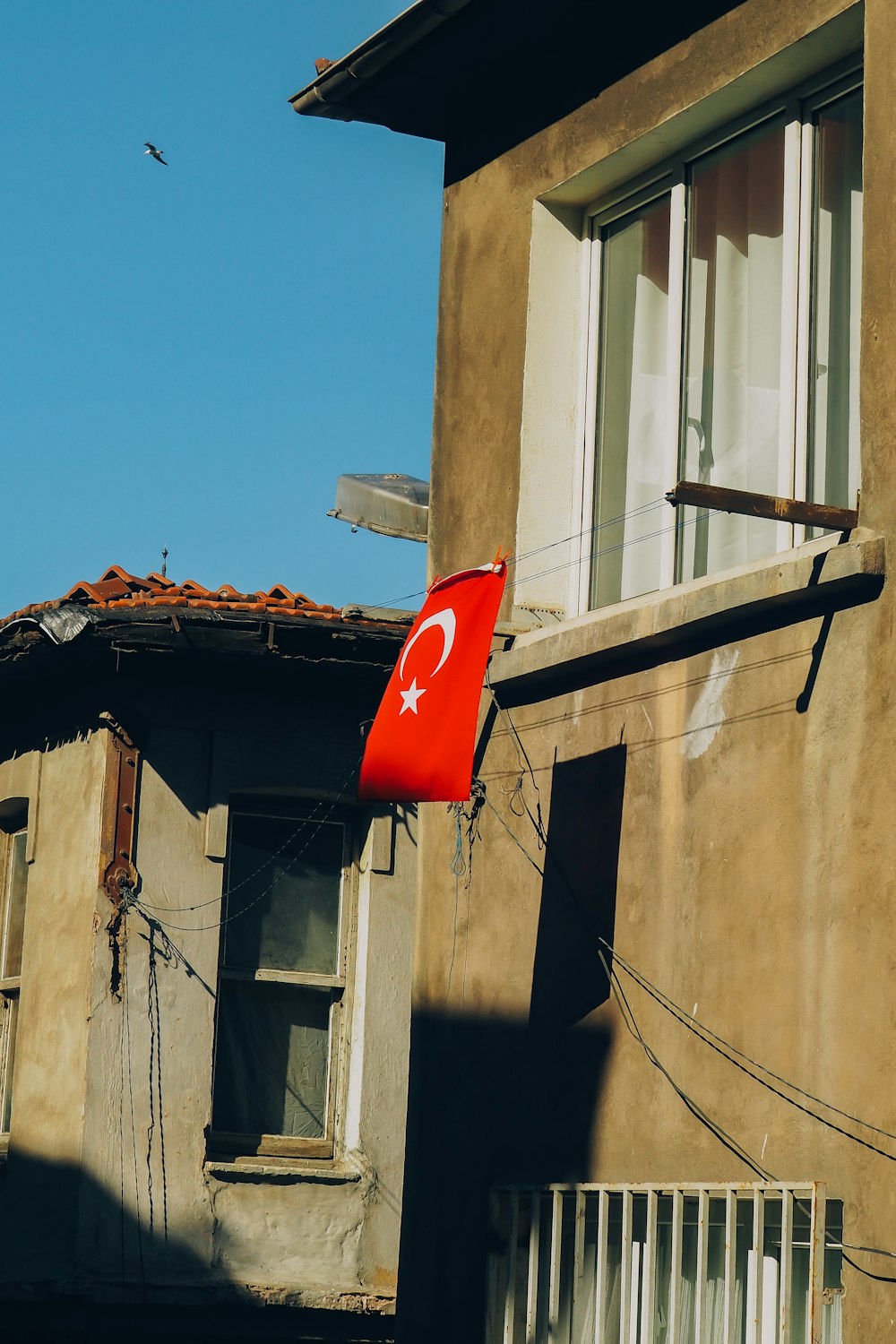 a red flag hanging from the side of a building