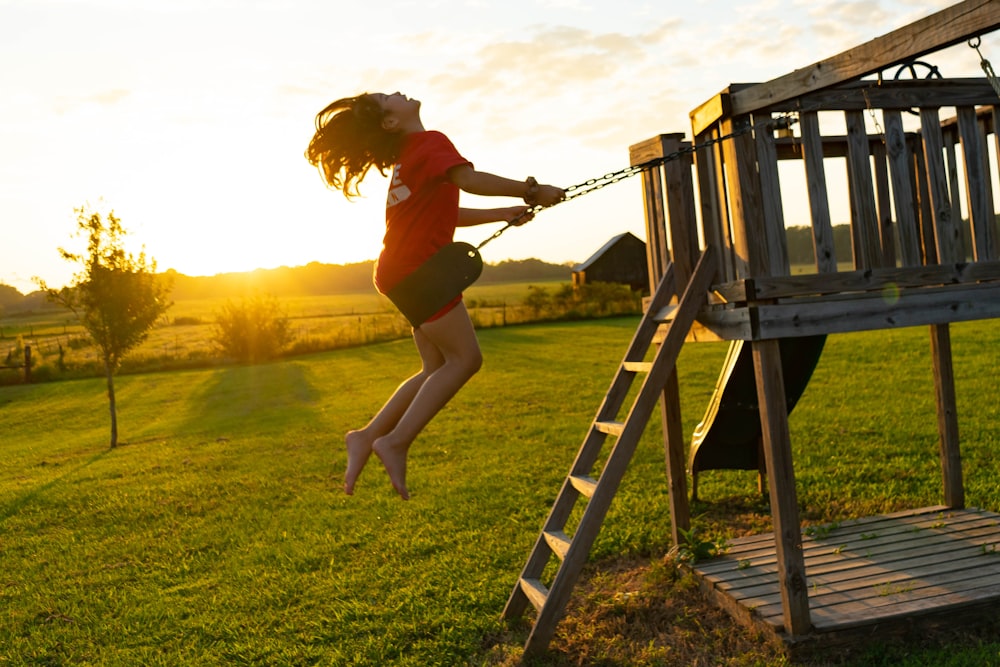 a young girl climbing up a wooden ladder