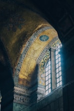 A warm-lit sanctuary with traditional Syriac crosses and deep red and gold accents.