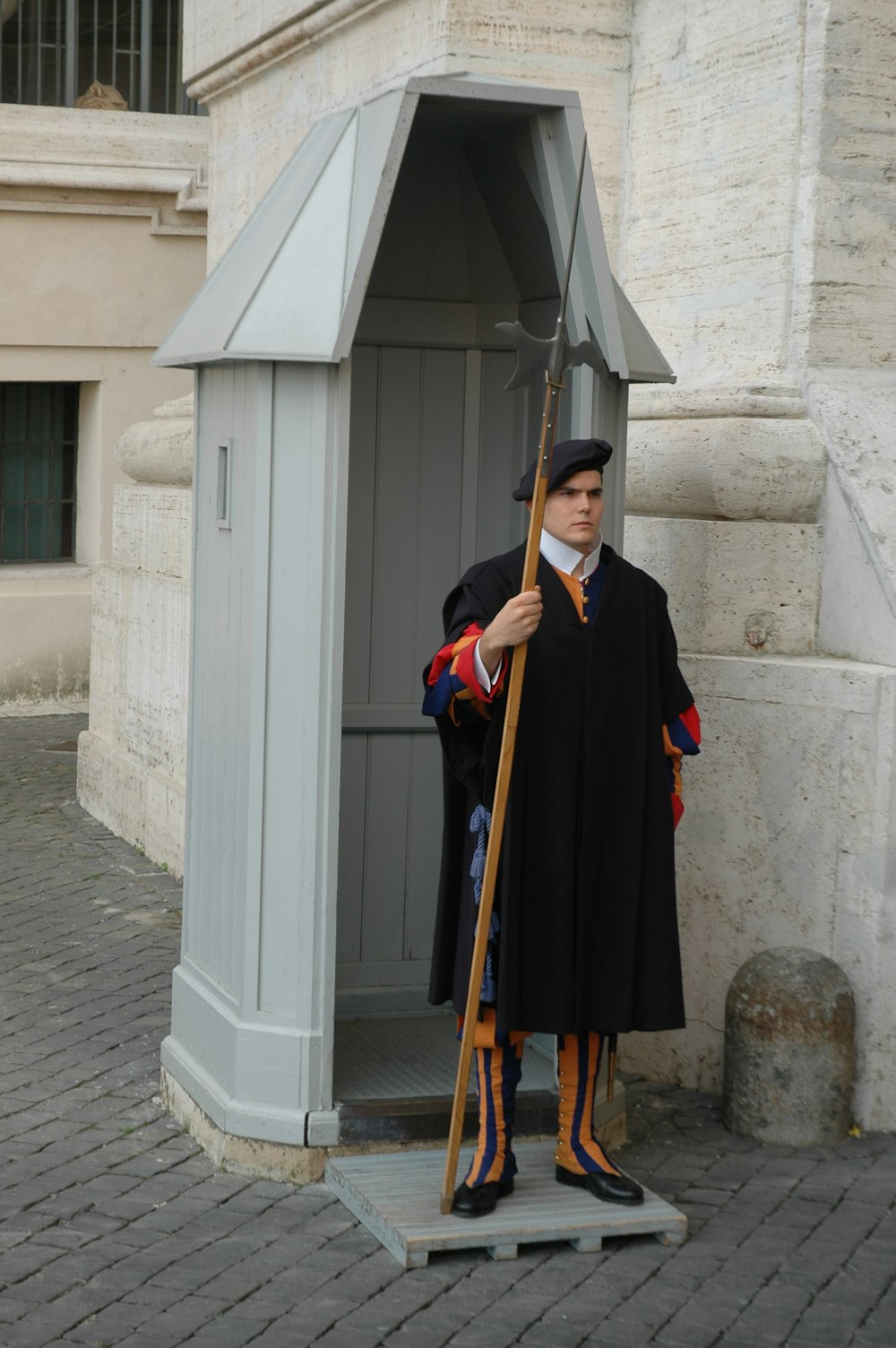 a statue of a man in a robe holding an umbrella