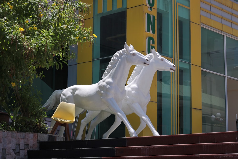 uma estátua de dois cavalos brancos de pé um ao lado do outro
