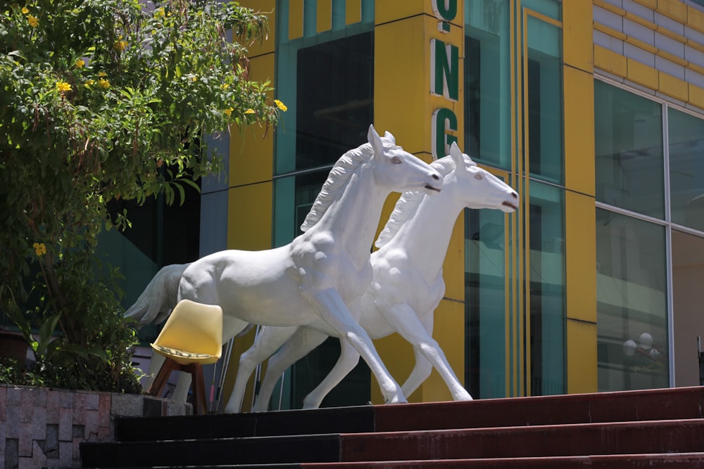 Una estatua de dos caballos blancos parados uno al lado del otro