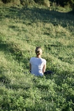 a woman sitting in a field of grass