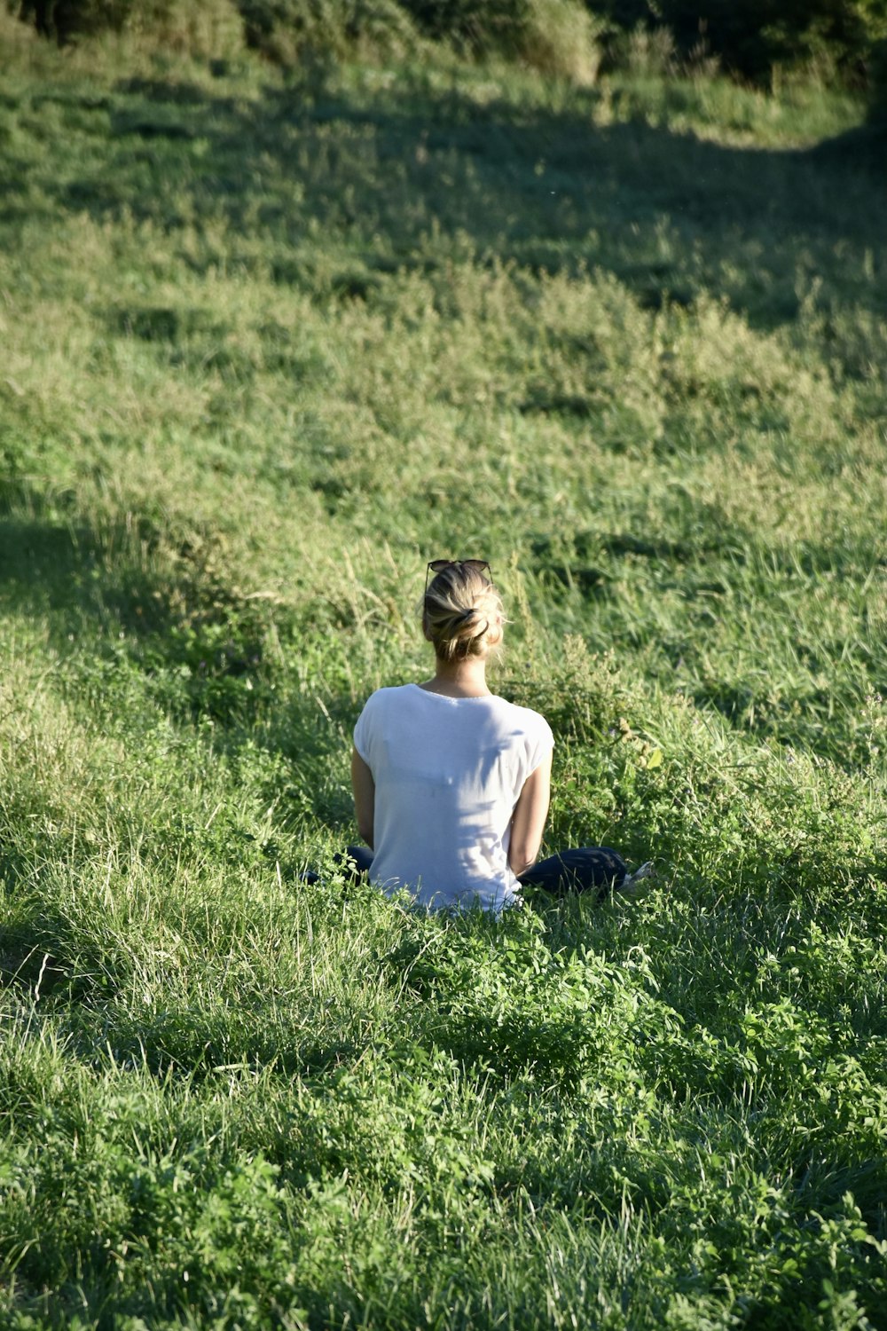 a woman sitting in a field of grass