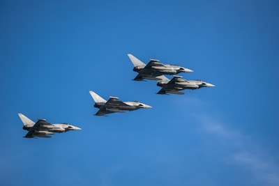 a group of fighter jets flying through a blue sky