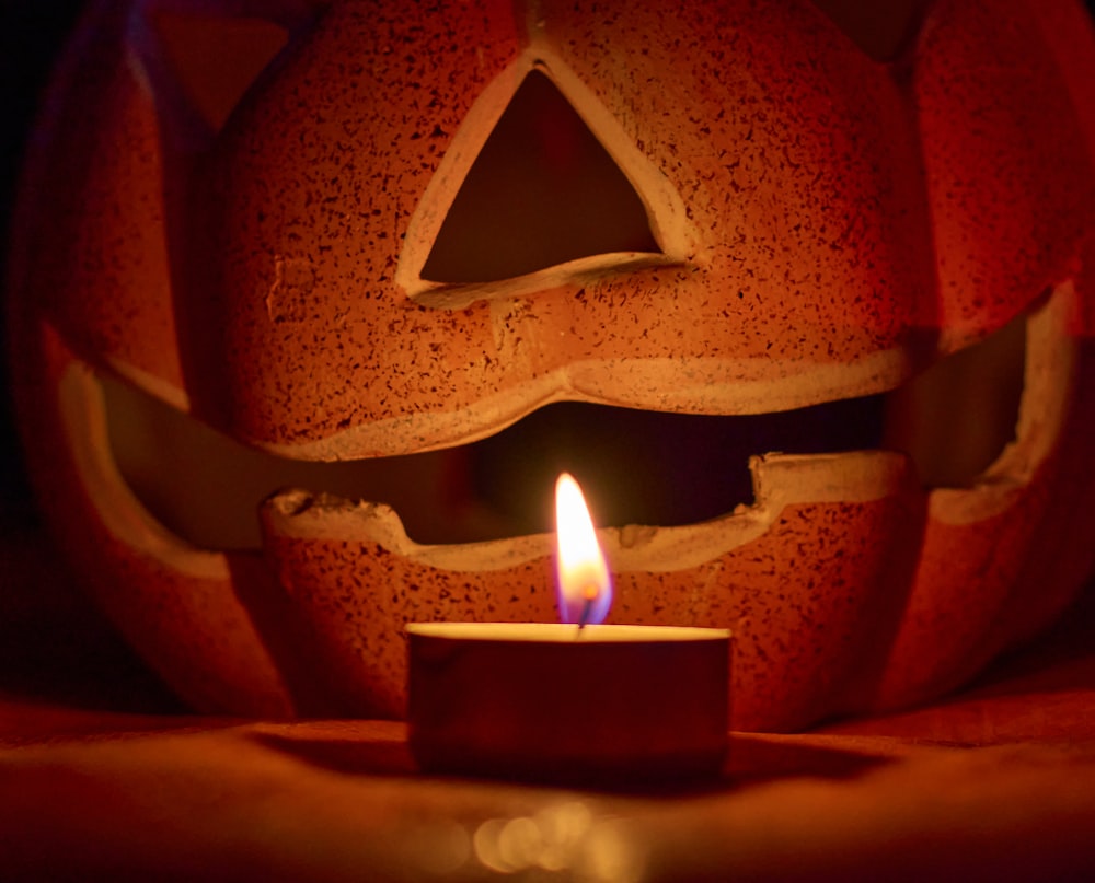 a pumpkin with a lit candle inside of it