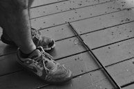 Close-up of textured SaltDan fishing shoes on wet rocks near a lake.