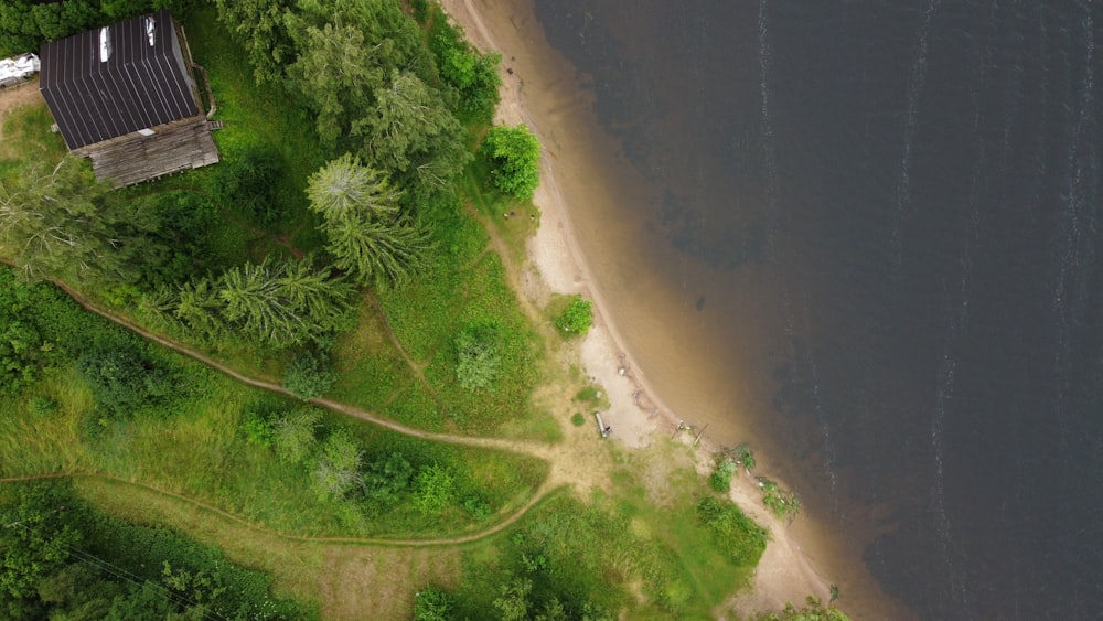 an aerial view of a house on the shore of a lake