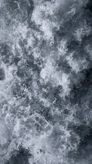 Chaotic and dynamic swirling water with abundant foam and bubbles. The water appears turbulent, suggesting movement and power.