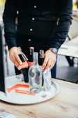 A smiling team member efficiently setting up drinks and snacks for an event.