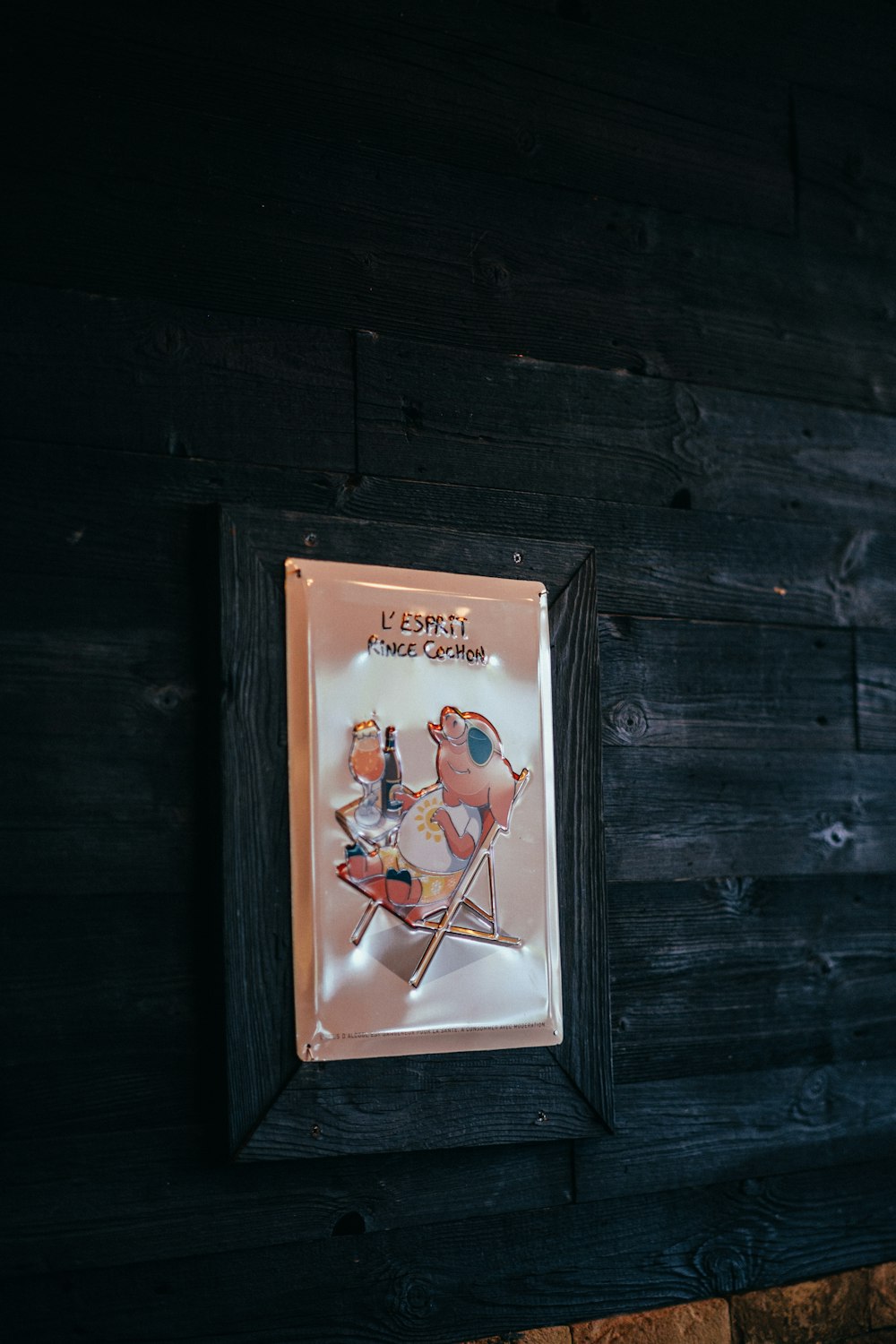 a wooden wall with a picture frame hanging on it