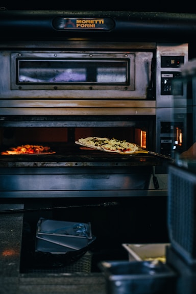 a pizza baking in an oven in a kitchen