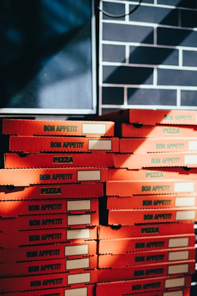 a stack of pizza boxes sitting on top of a table