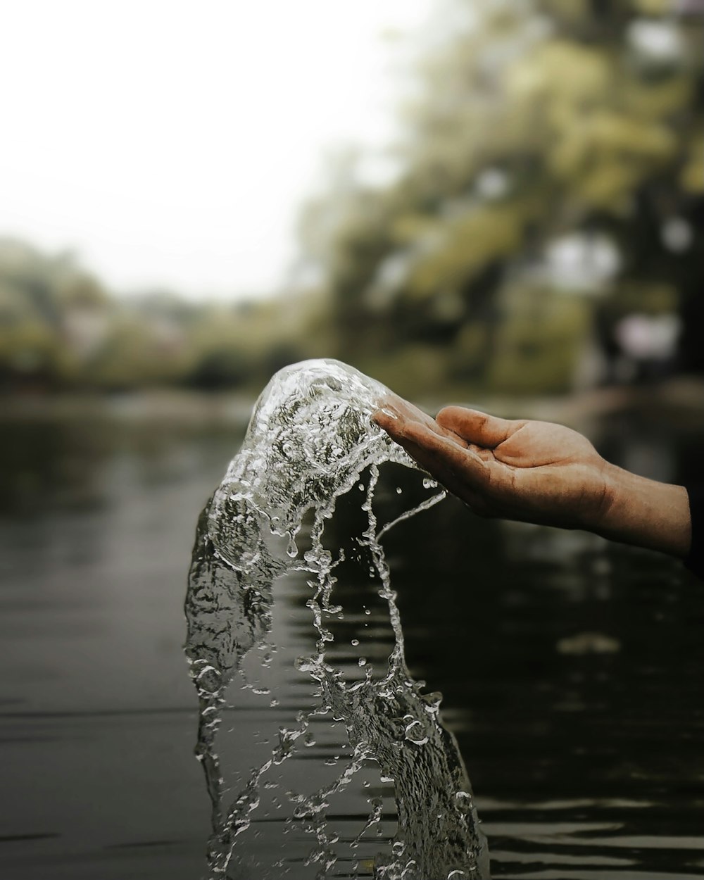a person is holding a plastic bottle in the water