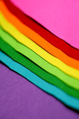 Close-up of colorful cartolina sheets fanned out on a table.