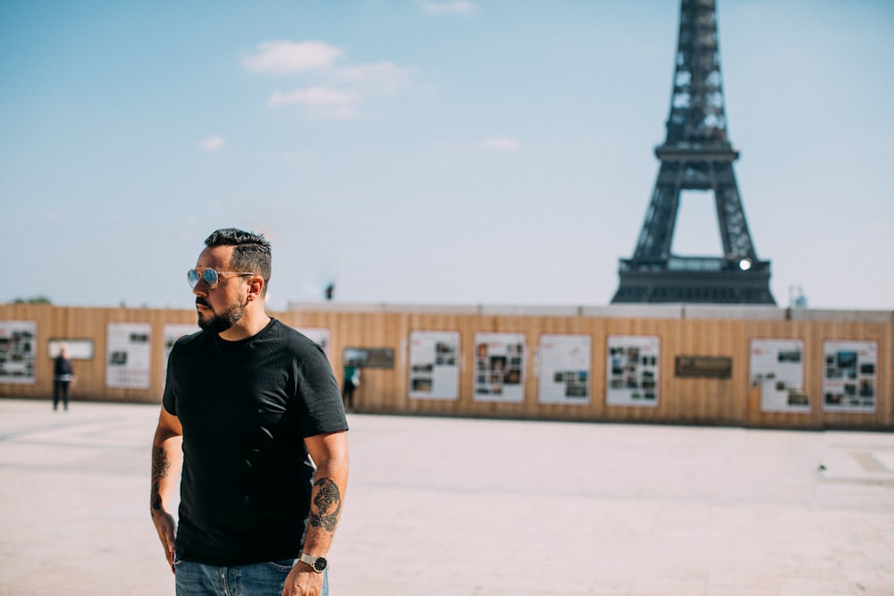 a man standing in front of the eiffel tower