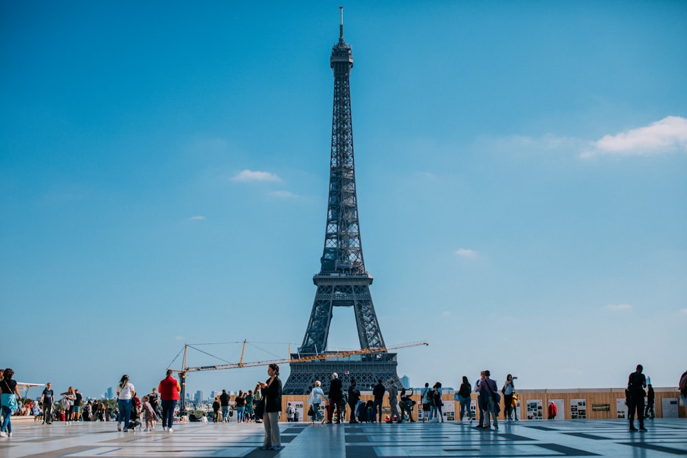 a group of people standing in front of the eiffel tower