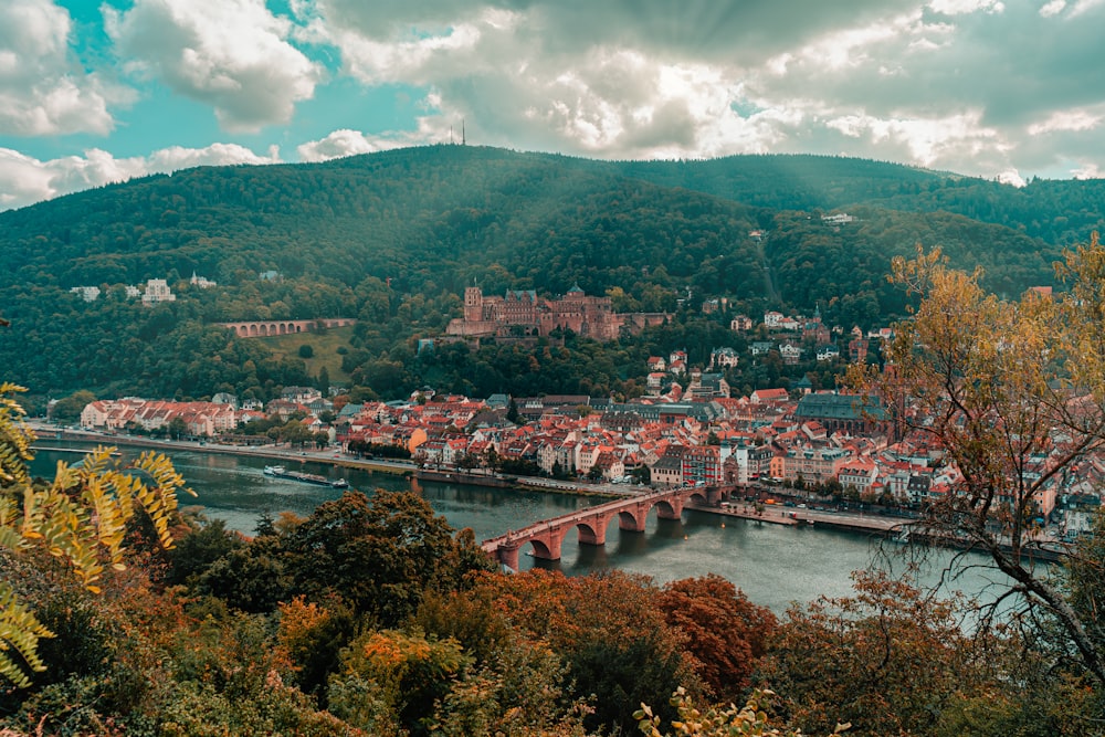 uma vista de uma cidade com uma ponte e montanhas ao fundo