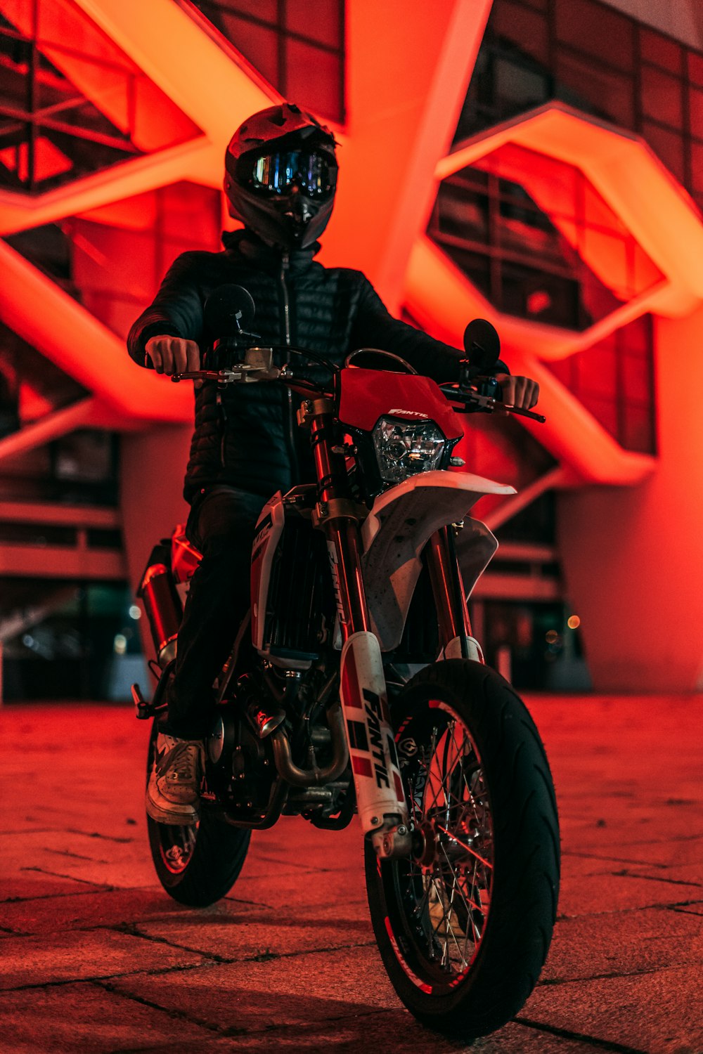 a man sitting on a motorcycle in front of a building