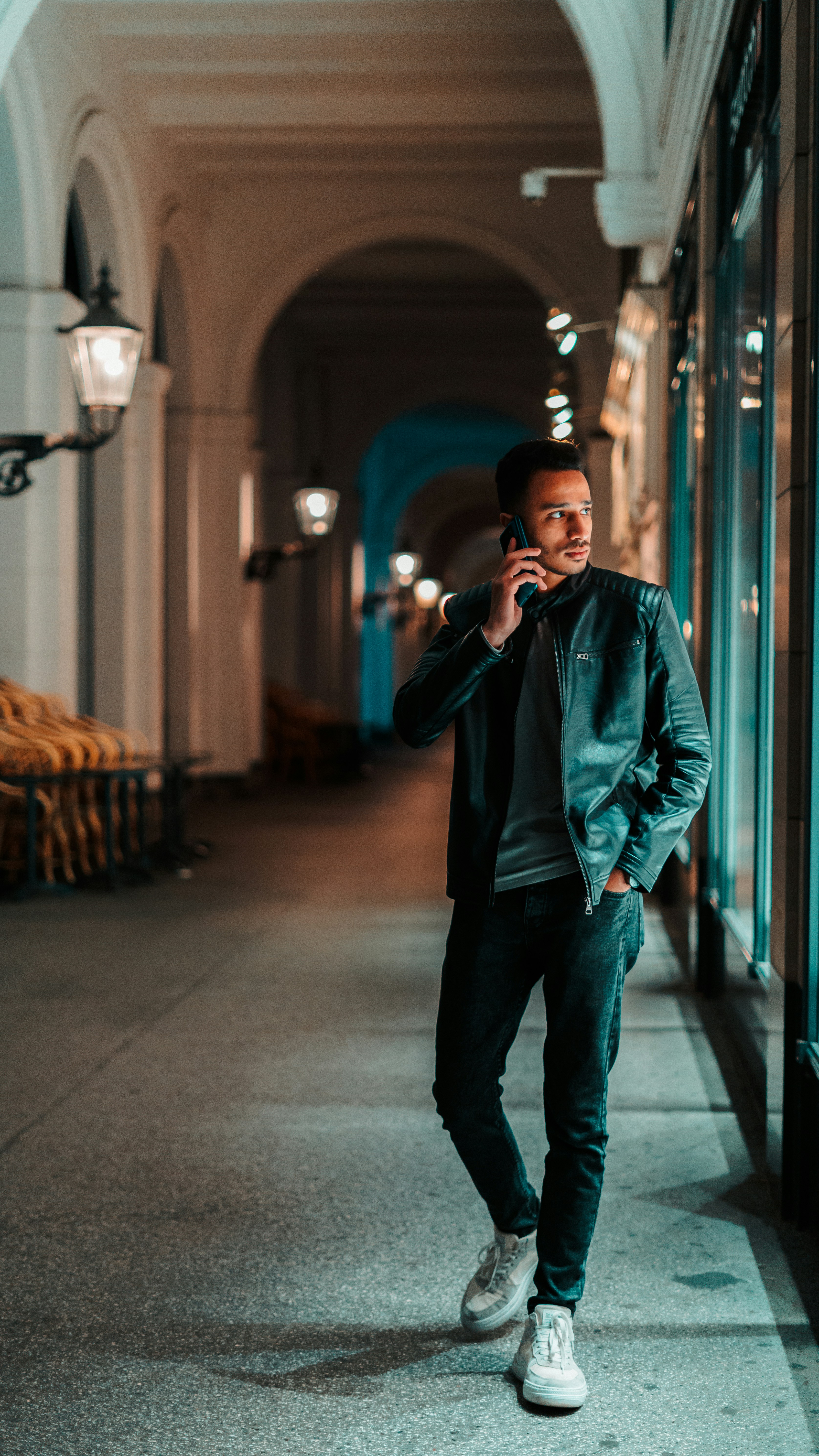 a man standing in a hallway talking on a cell phone