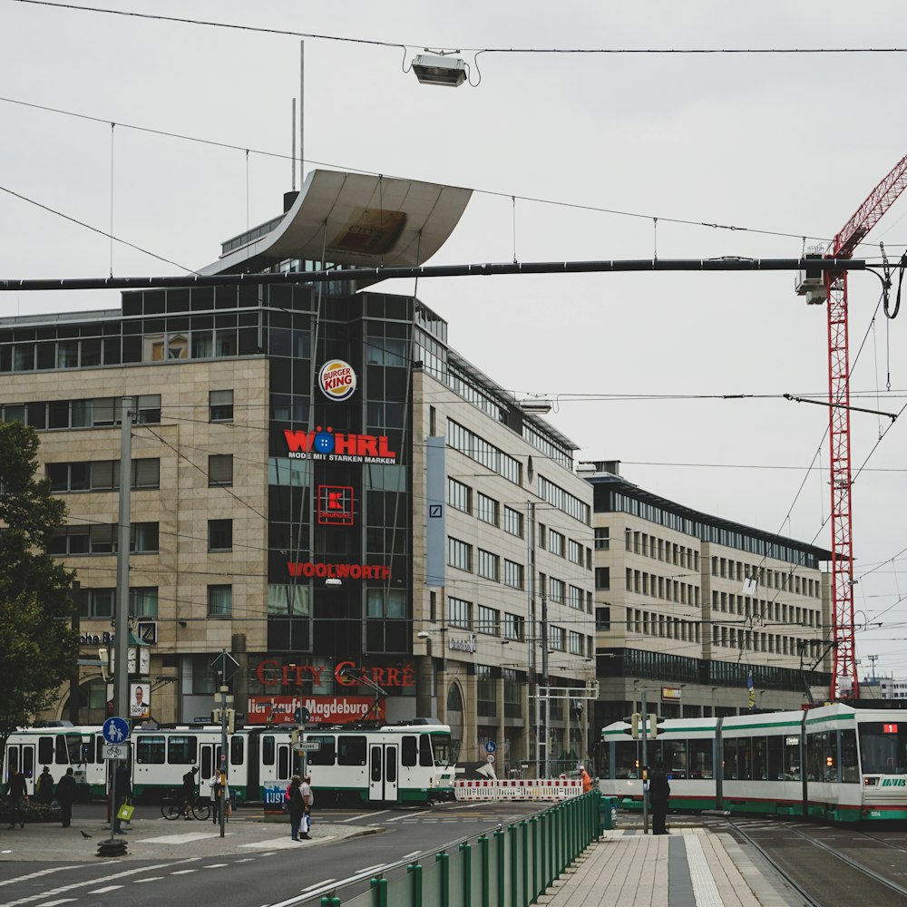 a street scene with a train on the tracks and a building in the background