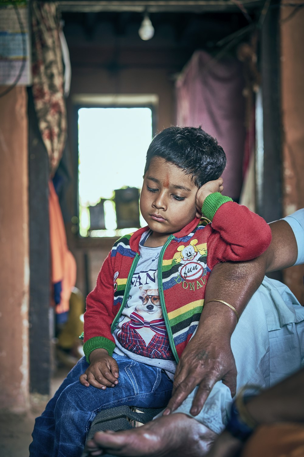 a young boy sitting on top of a person's lap