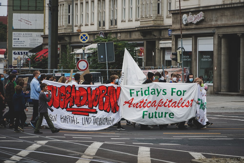 a group of people walking down a street holding a banner