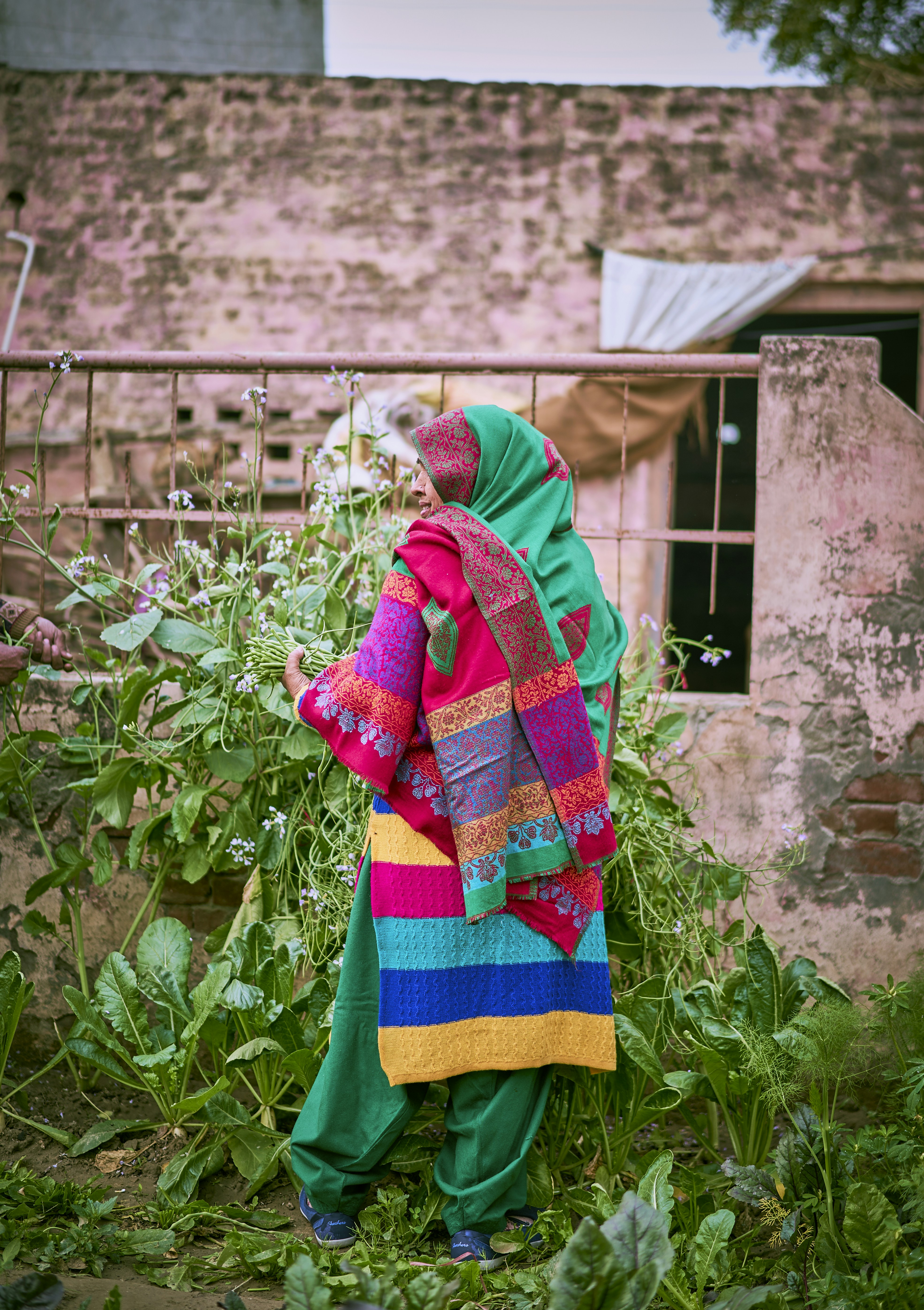 a woman in a colorful outfit standing in a garden