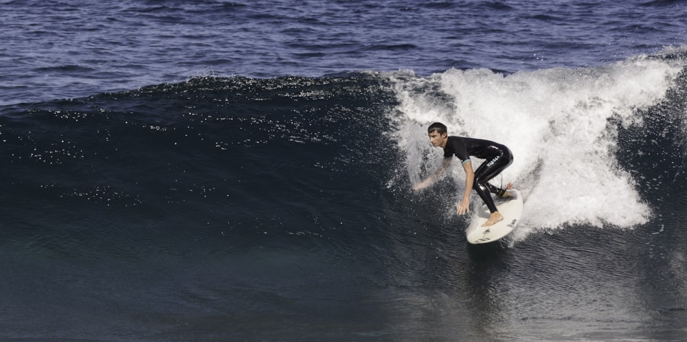 a man riding a wave on top of a surfboard