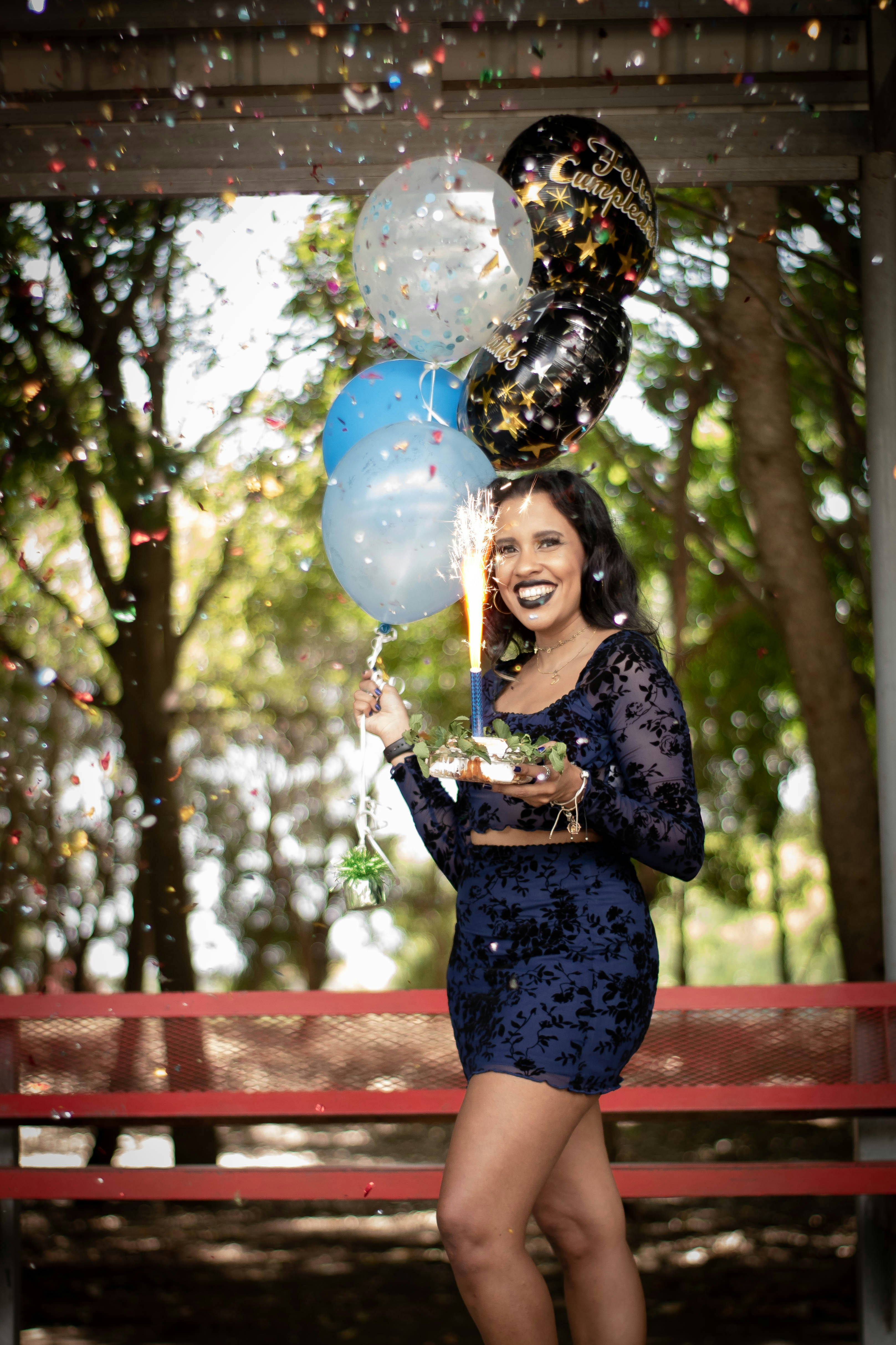a woman holding a plate of food and balloons