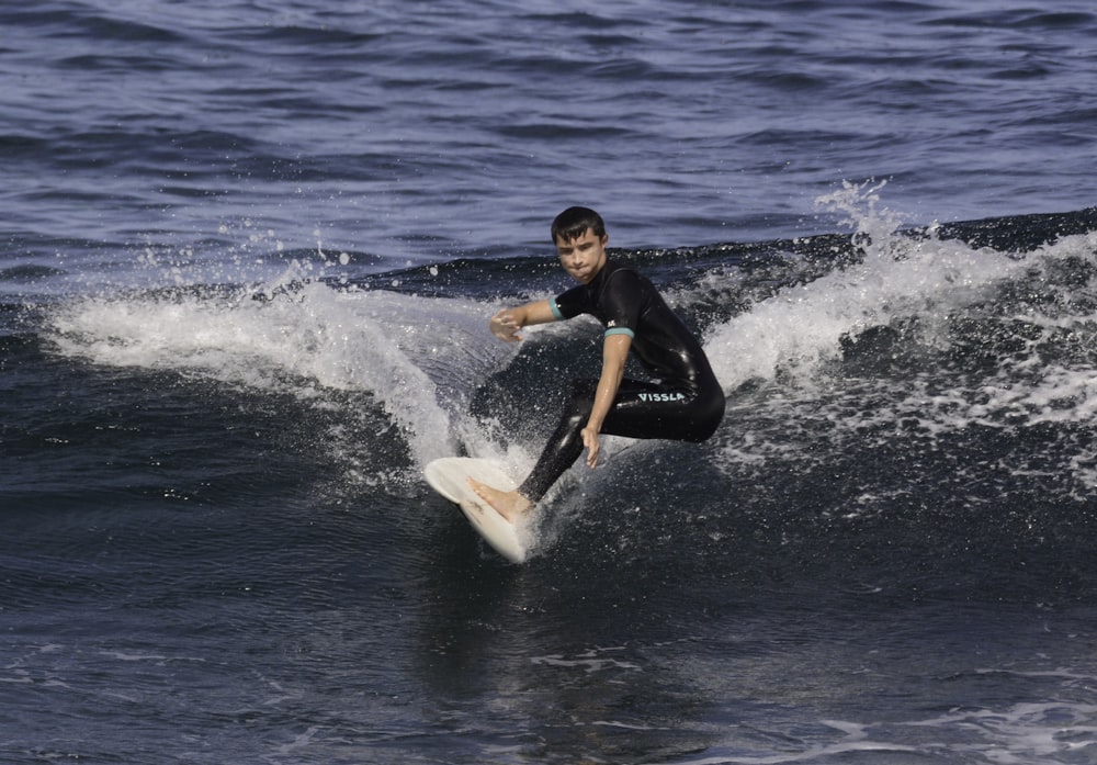 a man riding a wave on top of a surfboard