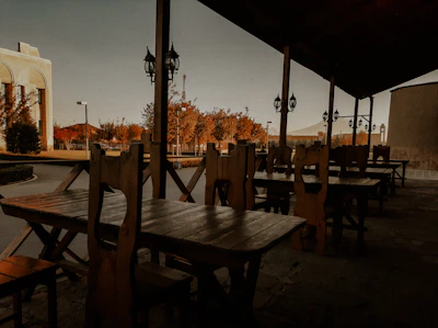 Weather-resistant outdoor dining set under soft evening light on a wooden deck.