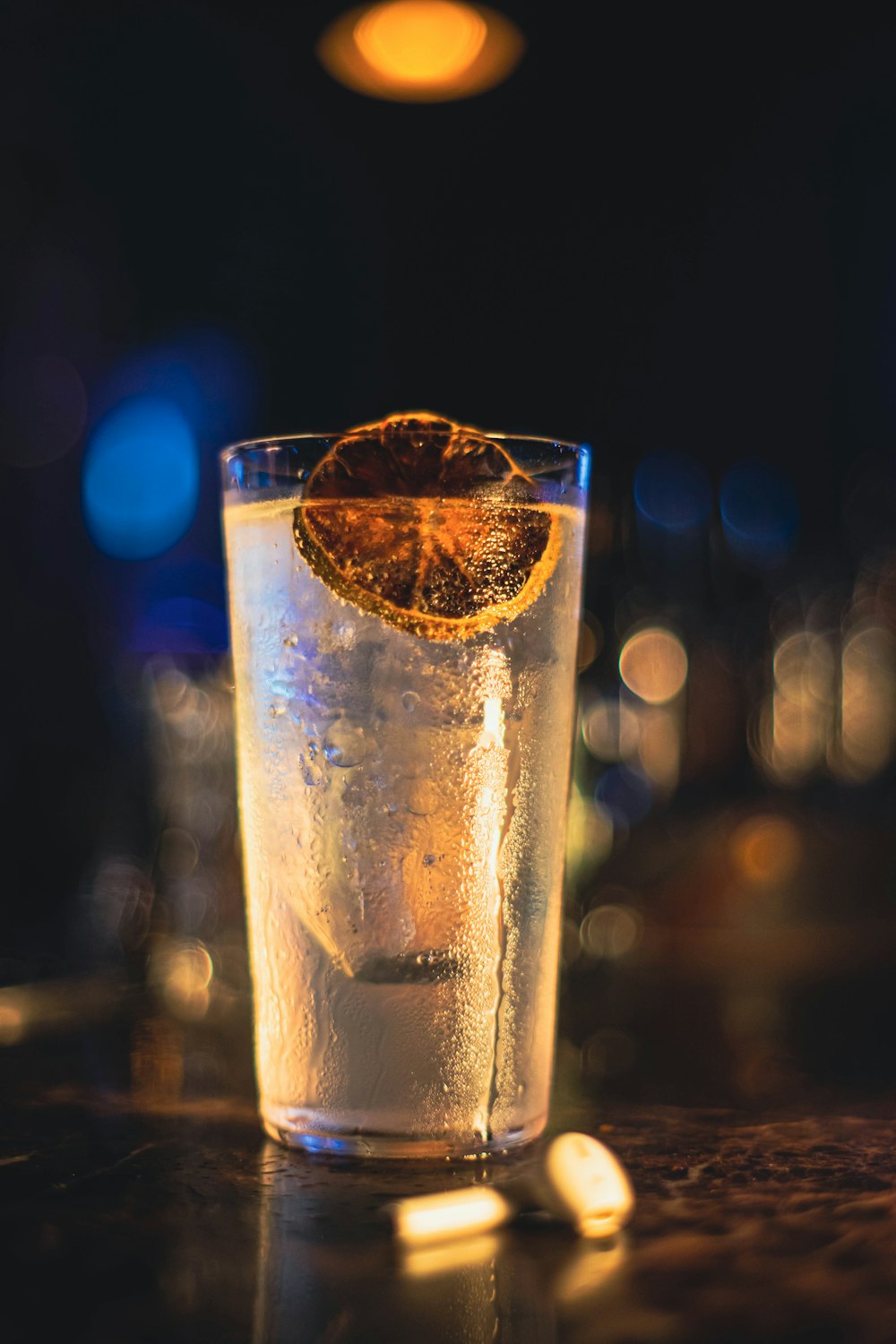 a glass filled with ice and an orange slice