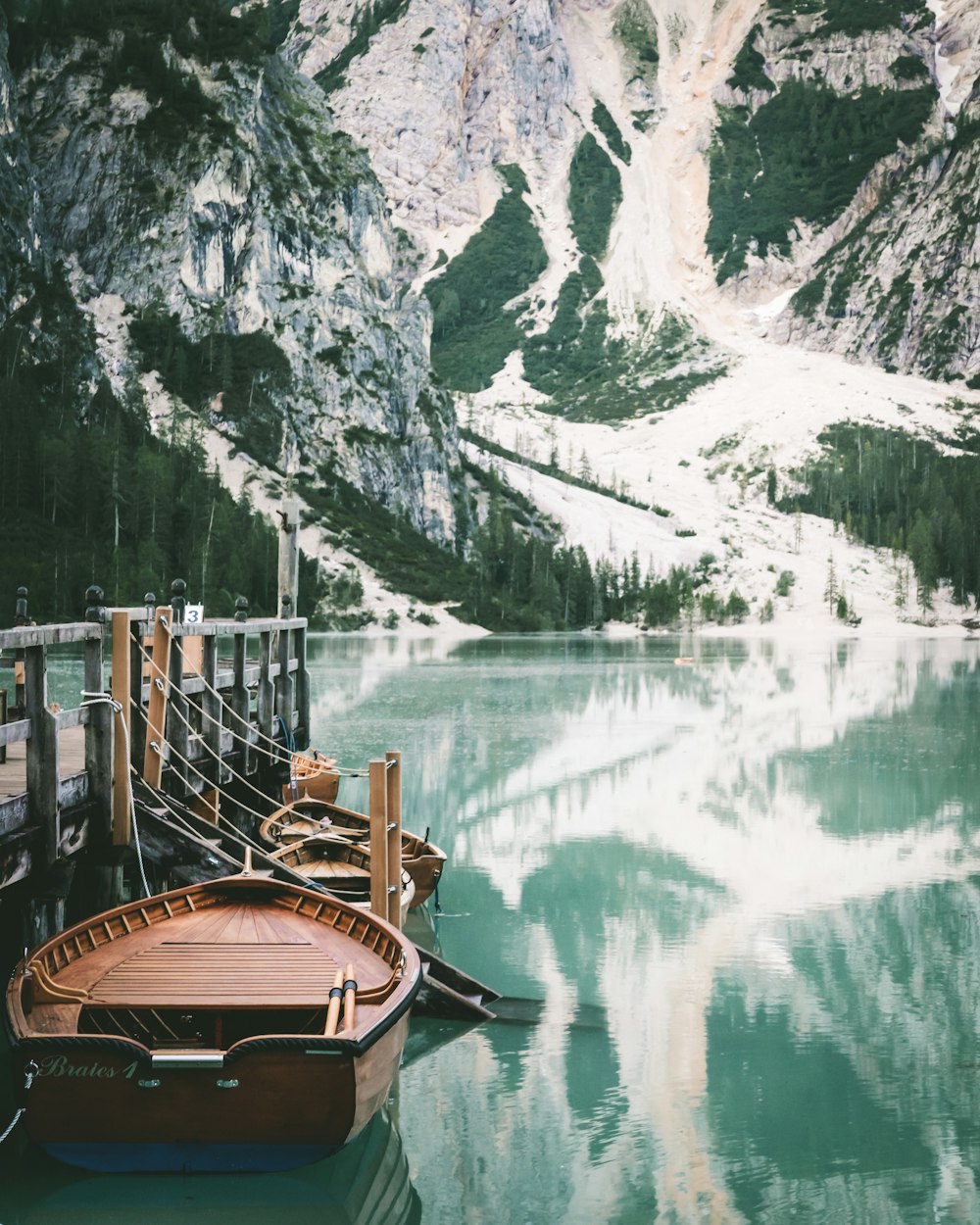 a boat sitting in the water next to a mountain