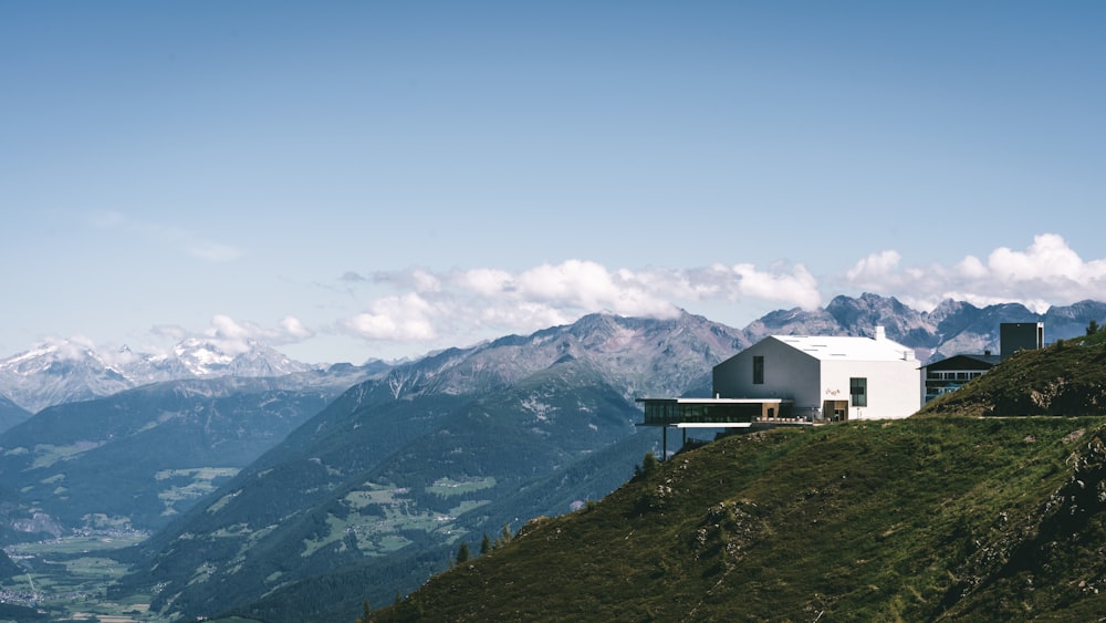 a house on a hill with mountains in the background