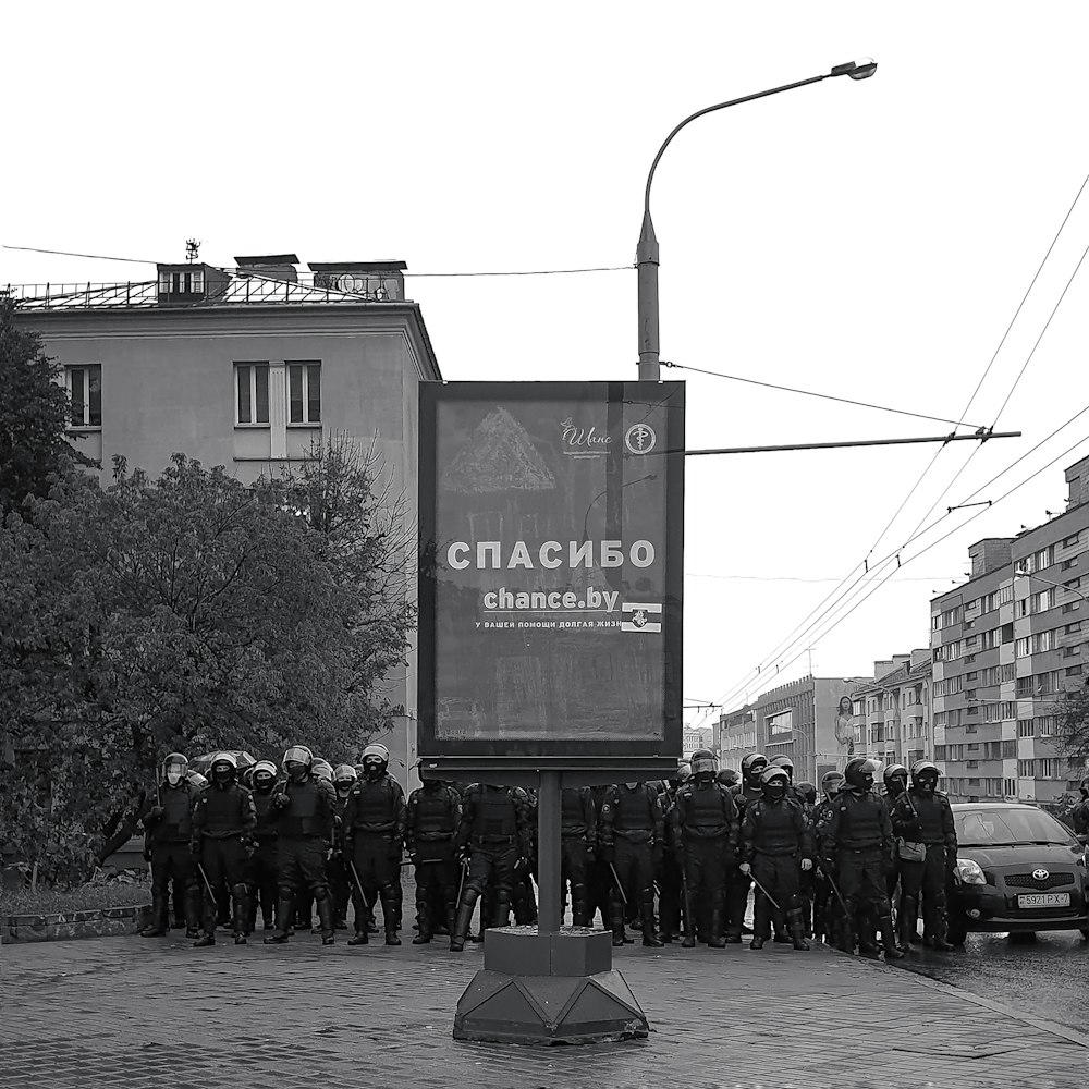 a group of people standing in front of a sign